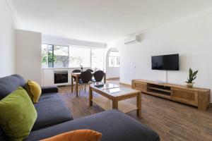 プラヤ・デル・イングレスにあるBungalows Lapahiのソファ、テレビ、テーブルのあるリビングルーム