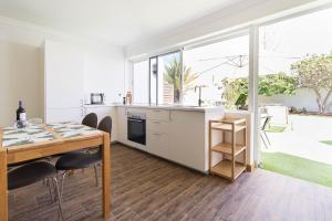 プラヤ・デル・イングレスにあるBungalows Lapahiのキッチン、ダイニングルーム(テーブル、大きな窓付)