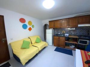 een kleine keuken met een gele bank in een kamer bij O Cabaça in Sesimbra
