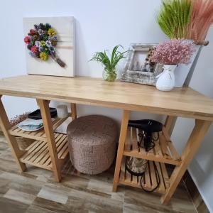 a wooden table with flowers in a room at Gió Rừng GuestHouse Đà Lạt in Da Lat