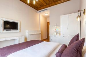 a bedroom with a bed and a tv on the wall at Orchis Hotel in Ayvalık