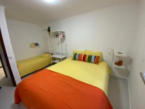 een slaapkamer met 2 bedden en een oranje deken bij O Cabaça in Sesimbra