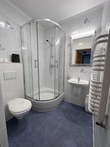 a bathroom with a shower and a toilet and a sink at Petrico Camp Resort in Krzywopłoty