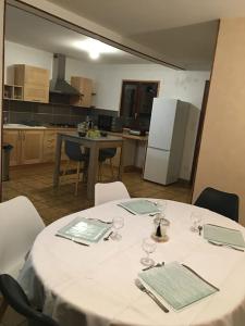 une cuisine avec une table, un chiffon de table blanc et des verres dans l'établissement Maison de ville, à Romorantin-Lanthenay