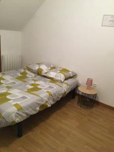 - un lit dans une chambre avec une table de chevet dans l'établissement Maison de ville, à Romorantin-Lanthenay