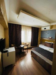 a bedroom with a bed and a desk and a tv at Meta Hotel in Bursa +61 photos