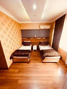 two beds in a room with wooden floors at Meta Hotel in Bursa