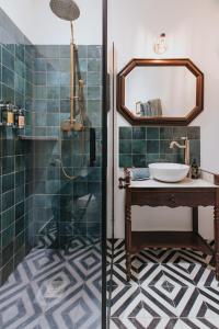 La salle de bains est pourvue d'un lavabo et d'une douche avec un miroir. dans l'établissement Maison Tassigny, à Meursault