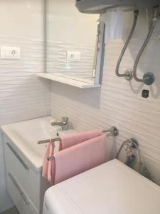 a bathroom with a toilet and a sink and a pink towel at Apartman Milica in Vrgada