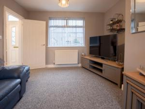 a living room with a couch and a flat screen tv at Pass the Keys Spacious house with free parking in Doncaster