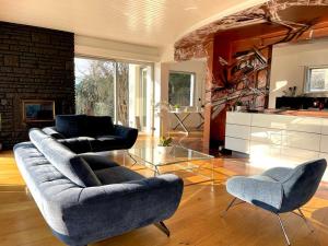 ein Wohnzimmer mit einem Sofa und 2 Stühlen in der Unterkunft Villa Colmar Centre avec Spa et double Parking in Colmar
