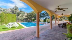 a patio with a pool and a ceiling fan at Villa la Quinta Priego de Córdoba by Ruralidays in Priego de Córdoba