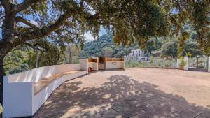 an outdoor patio with a white fence and a tree at Villa la Quinta Priego de Córdoba by Ruralidays in Priego de Córdoba