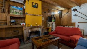 uma sala de estar com lareira e 2 cadeiras vermelhas em Bodega Ciprés Benaoján by Ruralidays em Benaoján