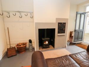 a living room with a fireplace and a couch at Cobbleken in Cockermouth