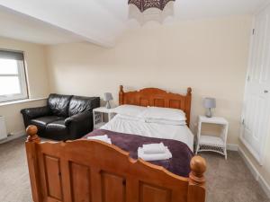 1 dormitorio con 1 cama grande y 1 sofá de cuero en Cobbleken en Cockermouth