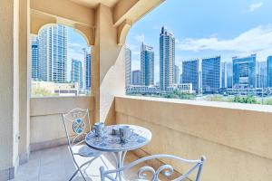 a table and chairs on a balcony with a view of the city at Golden Homes 1BR Reehan miniPalais Beside Burjh & Dubai mall Downtown in Dubai