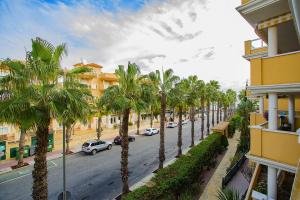 una calle con palmeras frente a un edificio en 241 Cabo Roig Sea View-Alicante Holiday, en Cabo Roig