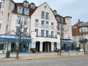 um grande edifício branco numa rua da cidade em Haus-Olymp-Apartement-01-Kuehlungsborn-nur-50-m-bis-zum-Strand-ca-50-m2-2-Raeume-sehr-gepflegt em Kühlungsborn