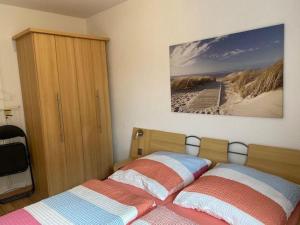 um quarto com uma cama e uma fotografia de uma praia em Haus-Olymp-Apartement-01-Kuehlungsborn-nur-50-m-bis-zum-Strand-ca-50-m2-2-Raeume-sehr-gepflegt em Kühlungsborn