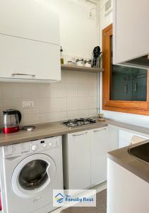eine weiße Küche mit Waschmaschine in der Unterkunft The Family Nest - Casetta con vista in Vittorio Veneto