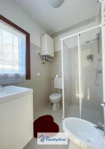 een badkamer met een douche, een wastafel en een toilet bij The Family Nest - Casetta con vista in Vittorio Veneto
