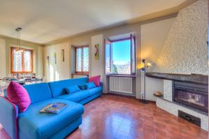 ein Wohnzimmer mit einem blauen Sofa und einem Kamin in der Unterkunft Anita Lake Fitness Retreat - Happy Rentals in Gemonio