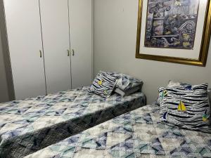 ein Schlafzimmer mit 2 Betten und einem Bild an der Wand in der Unterkunft RyQ-C in Jeffreys Bay