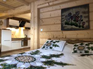 sypialnia z łóżkiem z 2 poduszkami oraz kuchnia w obiekcie Apartamenty Willa Szafran z widokiem na góry w Zakopanem