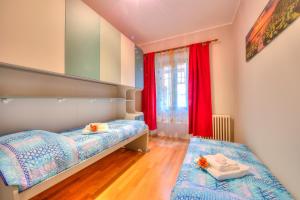 a bedroom with two beds and a window with red curtains at Anita Lake Fitness Retreat - Happy Rentals in Gemonio +35 photos
