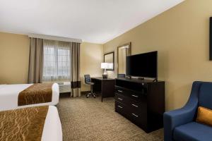 a hotel room with a bed and a flat screen tv at Comfort Inn Yankton SD in Yankton