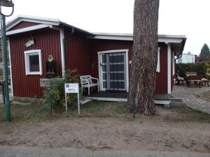 a red house with a tree in front of it at Schwedenhaus in Mönkebude