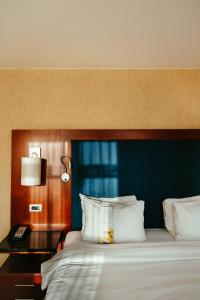 une chambre avec un grand lit et une tête de lit bleue dans l'établissement Ghent Marriott Hotel, à Gand