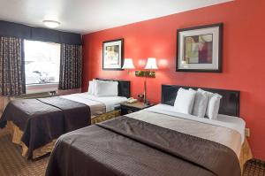 - 2 lits dans une chambre d'hôtel aux murs rouges dans l'établissement Econo Lodge Dalhart Hwy 54 - Hwy 287, à Dalhart