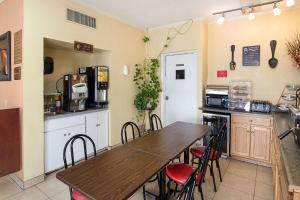 Il comprend une cuisine avec une table et des chaises en bois. dans l'établissement Econo Lodge Dalhart Hwy 54 - Hwy 287, à Dalhart