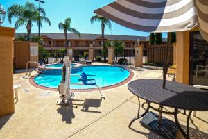 a swimming pool with a table and an umbrella at Econo Lodge Inn & Suites Corpus Christi in Corpus Christi