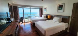 a hotel room with two beds and a balcony at Radisson Resort & Spa Hua Hin in Cha Am