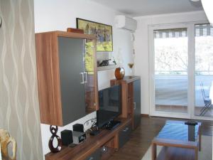 a living room with a tv and a entertainment center at Apartment Oliva with sea view in Fažana