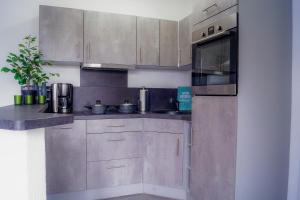 a kitchen with stainless steel cabinets and a microwave at Schöne Wohnung Kleiner Onkel auf idyllischem Reiterhof nahe Burg Eltz in Münstermaifeld