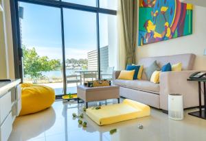 a living room with a couch and a large window at Cassia Phuket in Bang Tao Beach