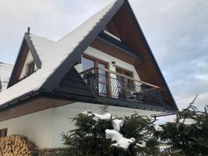 ein Haus mit einem Dach mit einem Balkon in der Unterkunft Apartamenty Willa Szafran z widokiem na góry in Zakopane