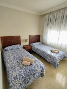 a bedroom with two beds and a window at Apartamento 3 dormitorios Roda Golf in Murcia