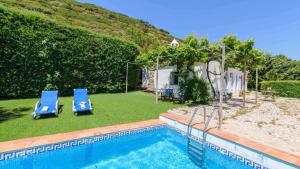 ein Pool mit zwei blauen Stühlen neben einem Haus in der Unterkunft Torcalillos Antequera - La Joya by Ruralidays in Antequera