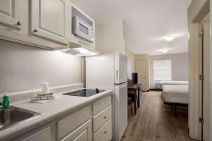 a kitchen with a sink and a refrigerator in a room at Suburban Studios Denver Central-Arvada in Arvada