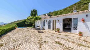 ein weißes Haus mit einer Terrasse und einem Hügel in der Unterkunft Torcalillos Antequera - La Joya by Ruralidays in Antequera