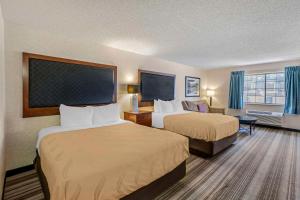 a hotel room with two beds and a flat screen tv at Quality Inn Denver Tech Center in Englewood