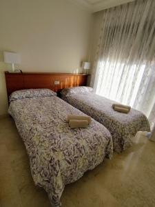 1 dormitorio con 2 camas y ventana en Apartamento 3 dormitorios Roda Golf, en Murcia