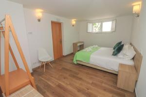 a bedroom with a bed and a wooden floor at Little Break Guest House in Lagos