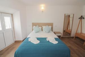 a bedroom with a blue bed with towels on it at Little Break Guest House in Lagos