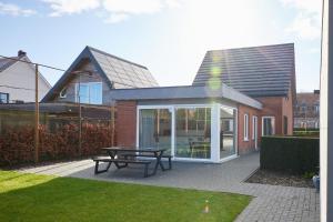 a patio with a picnic table in front of a house at Holiday Home De Steenen Molen in Brecht